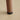 Brown cylindrical object with black base on a beige surface