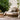 Round wicker daybed with cushions in a garden setting