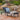 Charmydecor Puerta outdoor chaise lounge with dark gray cushion beside a landscaped pool and waterfall