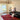 CharmyDecor red patchwork area rug with black leather sofa chandelier and warm transitional living room decor