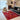 CharmyDecor red patchwork area rug in contemporary living room with black leather sofa and neutral lounge chair