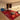 CharmyDecor red patchwork area rug with white sectional sofa blue lounge chair and modern glass coffee tables
