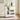 White kitchen cart with wooden top, appliances, and food items in a room.