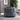 Gray round ottoman in a living room setting with a plant and wall art.