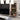 Wooden bookshelf in a living room with decor items and a TV in the background.