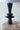 Black ceramic lamp on a wooden surface with a white background