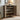 Wooden shoe cabinet with open doors displaying various shoes, placed against a neutral wall.