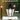 Outdoor lamp with clear glass shade and black metal fixture, raining background, IP44 rating label.