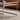 Coffee table with metal frame and wooden top in a living room setting