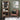 Wooden bookshelf with books and a brown leather chair against a green wall with abstract art.