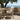 charmydecor teak finish wicker outdoor chair with white cushion beside patio table and ocean view