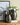 Three decorative vases on a table with a framed picture in the background