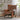 Brown leather armchair in a living room setting with plants and a side table.