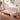Pink sofa with a blanket in a living room setting