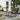Two black outdoor wicker lounge chairs with iron frames beside a patio grill and coffee table - charmydecor