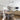Dining room with wooden table and chairs, ceiling fan, and living room area.