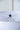 Close-up of a white lampshade with a black finial on a light gray background