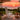 charmydecor white patio rocking chair in an outdoor lounge area overlooking a sunset ocean view