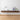 Wooden floating shelf with decorative items against a white wall.