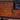 Close-up of bronze handle on whiskey maple cabinet door of the TV stand.