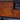 Close-up of bronze handle on whiskey maple cabinet door of the TV stand.