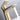 close up of brushed gold faucet spout with water flowing