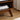 Close-up of the angled solid wood leg and lower open shelf, showing construction quality