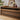 Close-up of walnut media console’s tempered glass drawer front and decor on top.