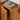 Close-up of hidden door handles on walnut cabinet with books on top