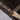 Detail of stitched PU leather handle wrap over polished gold bar on magazine rack.