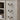 Detail shot of antique brass drawer-style handle on rustic gray wood cabinet door.