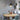 Farmhouse pendant light hanging above round light wood dining table