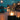 Fire column with glass cylinder by waterfront promenade at night