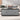 Gray lift top coffee table in living room with laptop and modern decor.