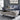 Modern gray lift-top coffee table placed in a contemporary living room setting with blue leather sofa