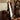 Mirror with wavy frame leaning near window with vintage decor