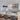 Modern gold linear crystal chandelier with 8 G9 bulbs elegantly illuminating a bright white kitchen with patterned tile backsplash and wood-accented island.