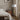 Modern tripod floor lamp beside a bed and nightstand in cozy bedroom