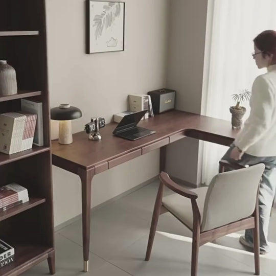 a solid walnut wood l-shaped desk with two drawers in a modern home office