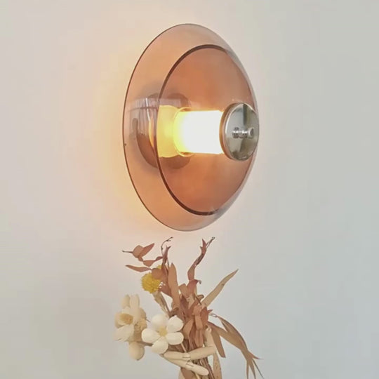 a plug in wall light sconce with amber glass shade illuminating light beautifully