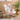 Side angle of pastel fabric rocking chair beside a coffee table and plant