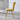 Side view of yellow velvet dining chair with padded bubble back and gold metal legs