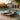 Two Charmydecor black acacia wood outdoor chaise lounges with dark gray cushions in a luxury poolside setting
