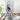 Person sitting in a blue floral-patterned hanging chair indoors.