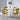Four yellow velvet bubble back chairs around white dining table with Eiffel Tower wall art
