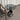 Contemporary Glass Pedestal End Table by a chair