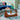 Wood glass coffee table with brown base complementing blue interior